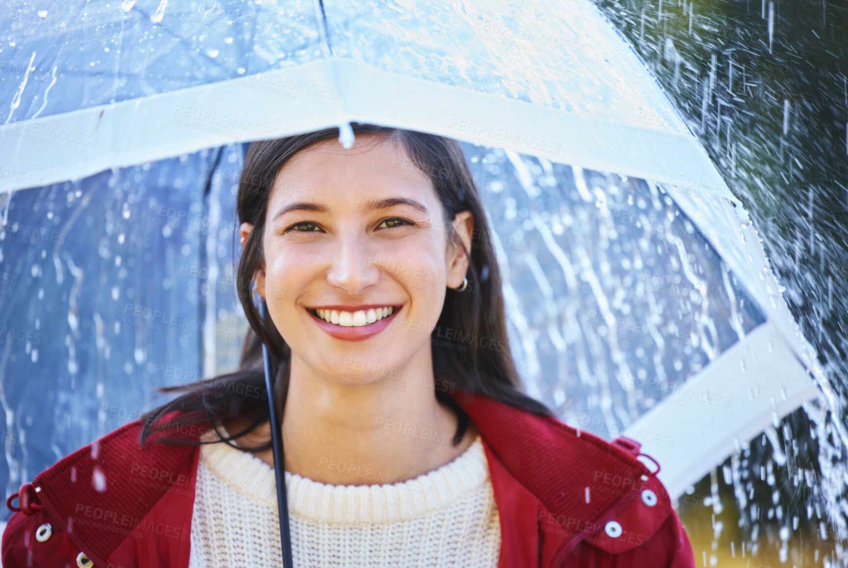 Buy stock photo Shot of a young woman holding an umbrella in the rain outside