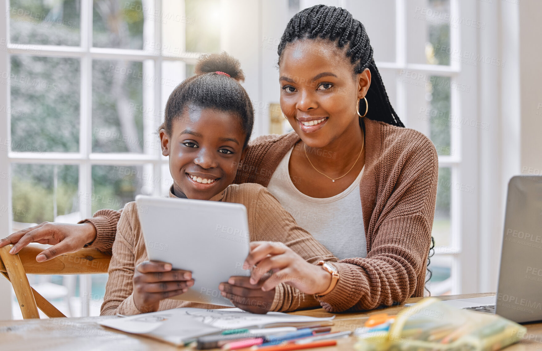 Buy stock photo Shot of a young mother and daughter using a digital tablet at home