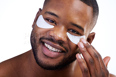 Buy stock photo Studio portrait of a handsome young man wearing under eye patches against a white background