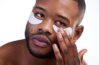 Buy stock photo Studio shot of a handsome young man wearing under eye patches against a white background