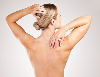 Buy stock photo Studio shot of an unrecognizable young woman posing with her back facing the camera against a grey background