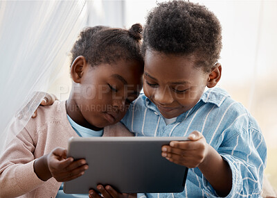 Buy stock photo Shot of a little boy and girl watching something together on a digital tablet