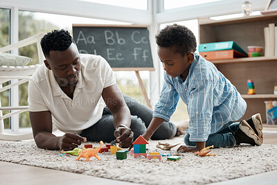 Buy stock photo Shot of a little boy and his dad playing with toys in his bedroom