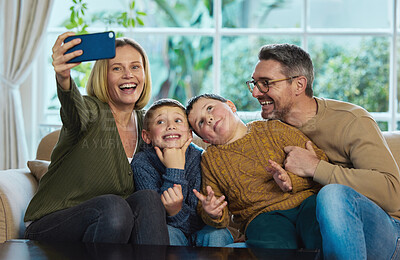 Buy stock photo Shot of a family taking a selfie using a smartphone