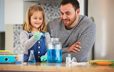 Buy stock photo Shot of a little girl completing scientific experiments with her dad at home