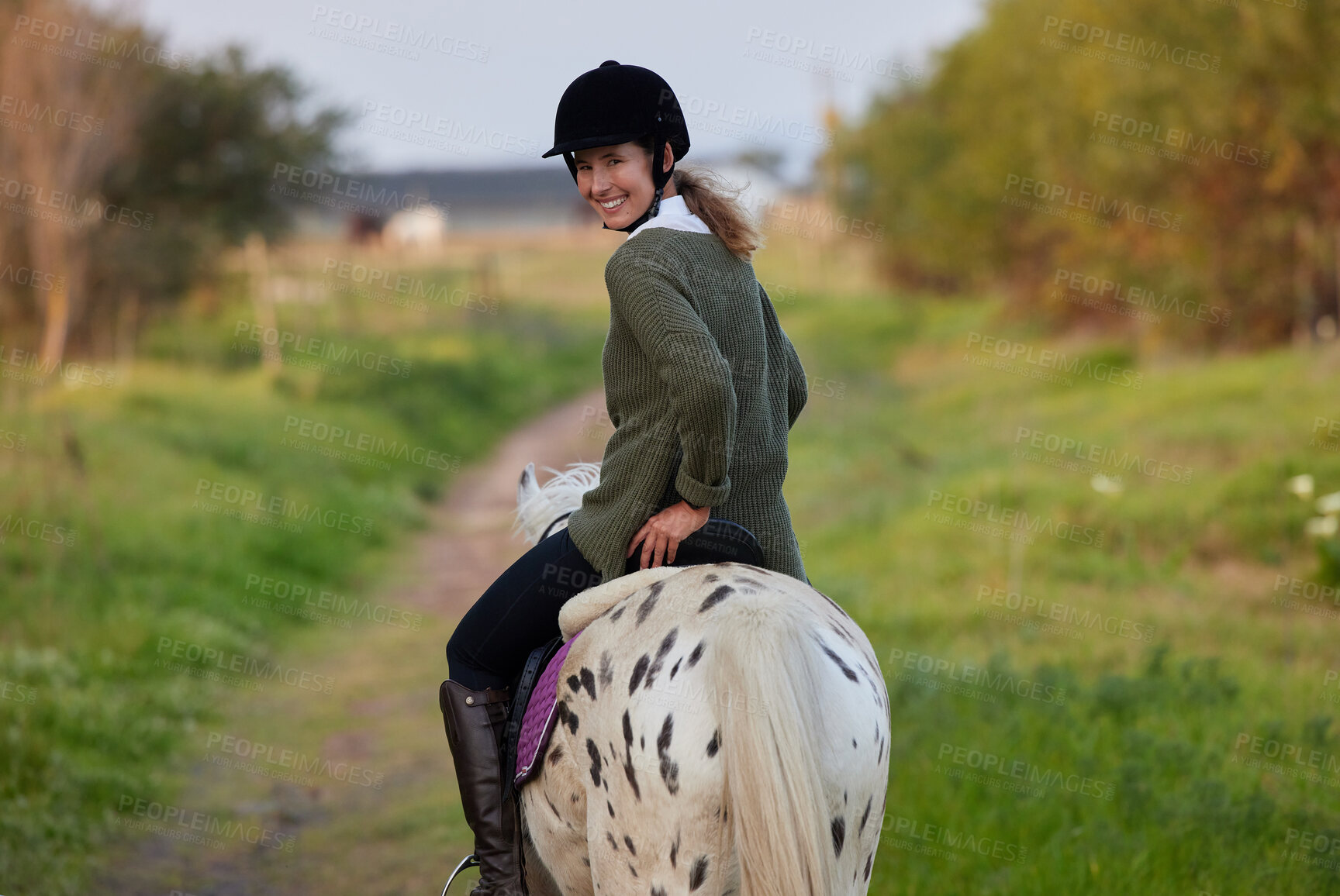 Buy stock photo Shot of a young woman riding her horses outside on a field
