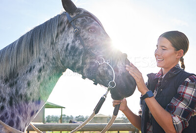 Buy stock photo Cropped shot of an attractive young woman petting her horse outside on the ranch