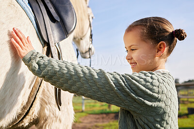 Buy stock photo Cropped shot of an adorable young girl petting her horse outside on the ranch