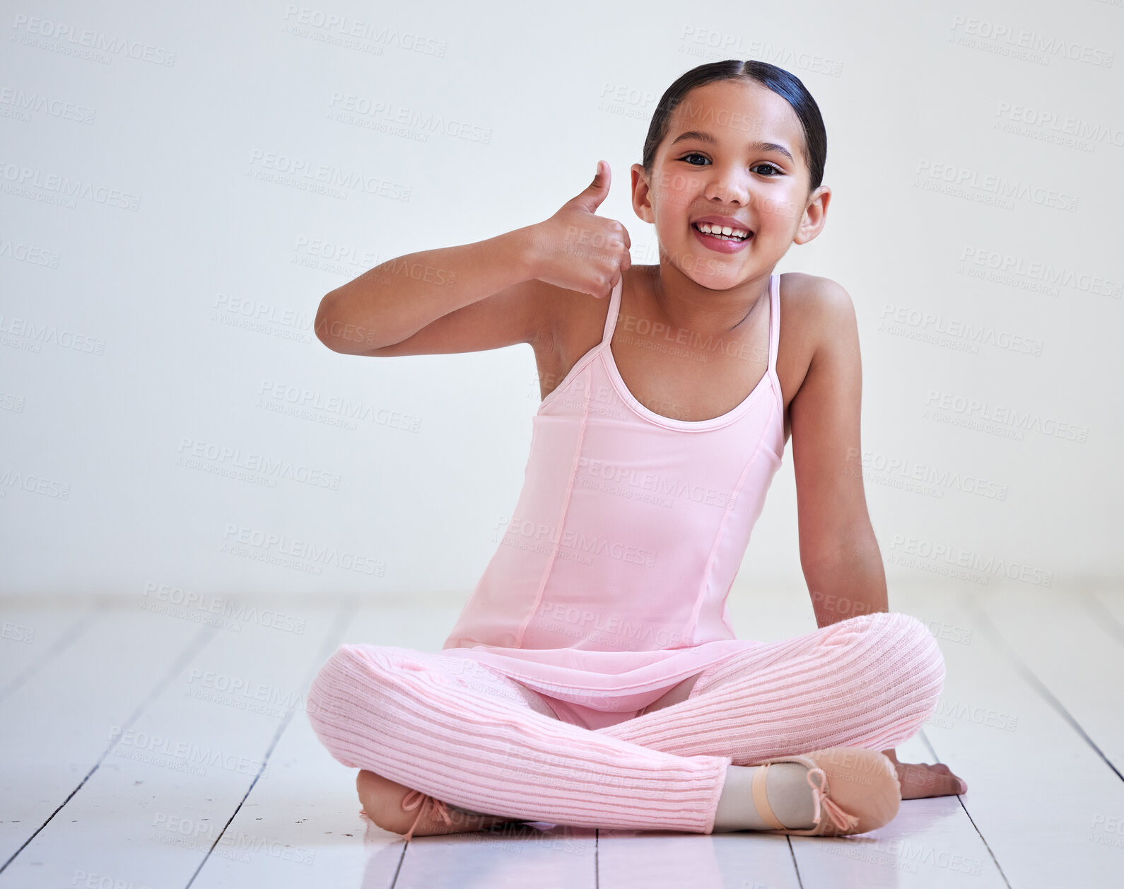 Buy stock photo Portrait of a little girl showing thumbs up in a ballet studio