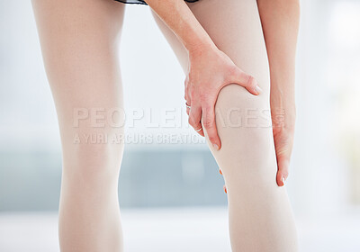 Buy stock photo Cropped shot of a ballerina holding her leg in pain