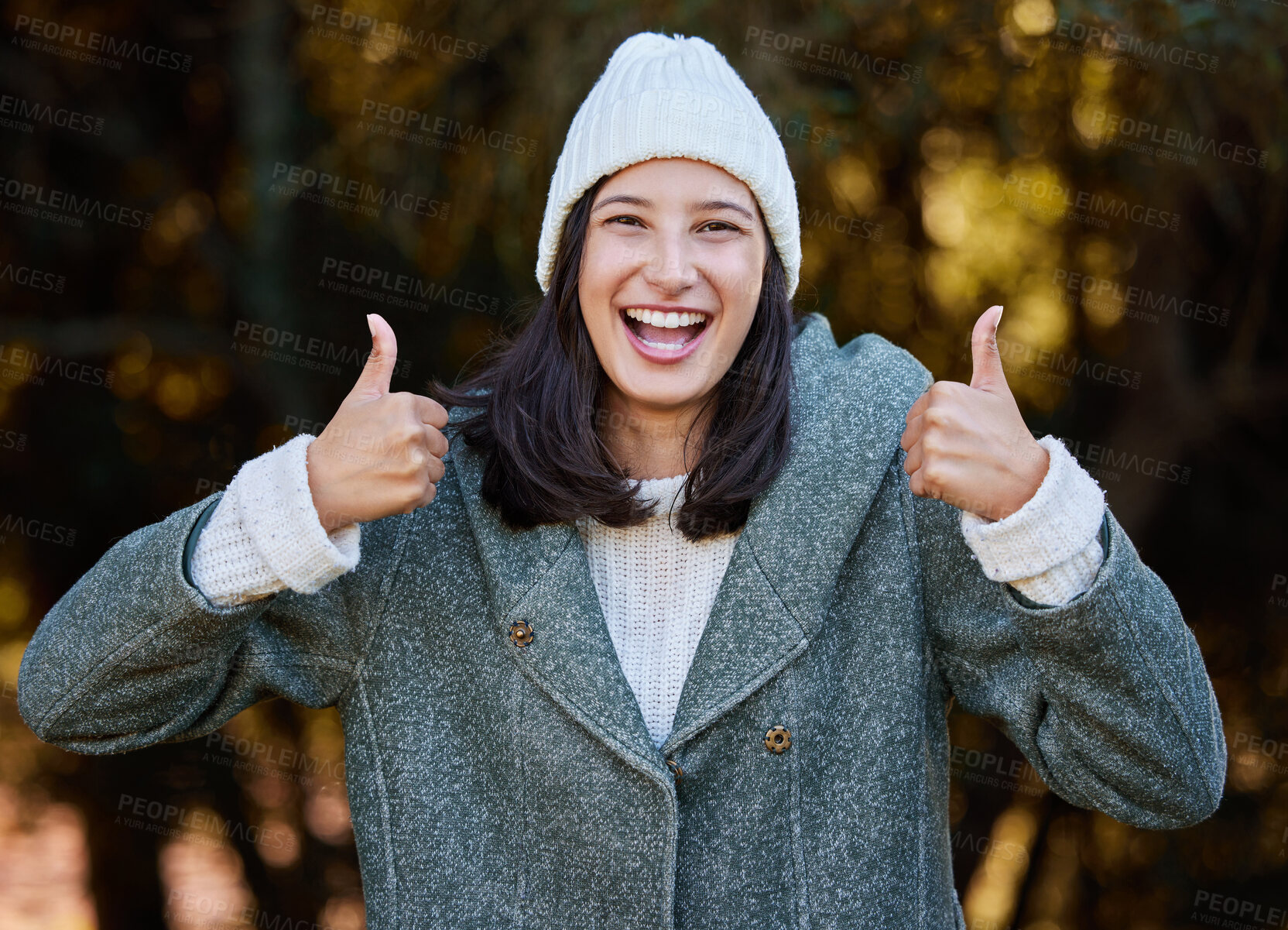 Buy stock photo Shot of an attractive young woman standing alone outside and showing a thumbs up