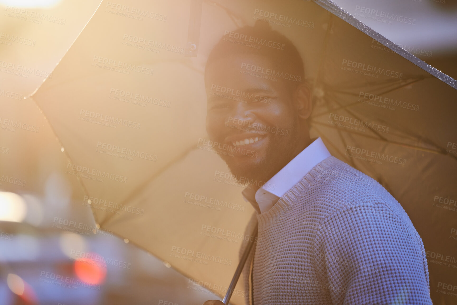 Buy stock photo Portrait of a young man holding an umbrella on a rainy day in the city