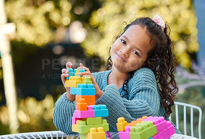 Buy stock photo Shot of a little girl playing with building blocks in her yard