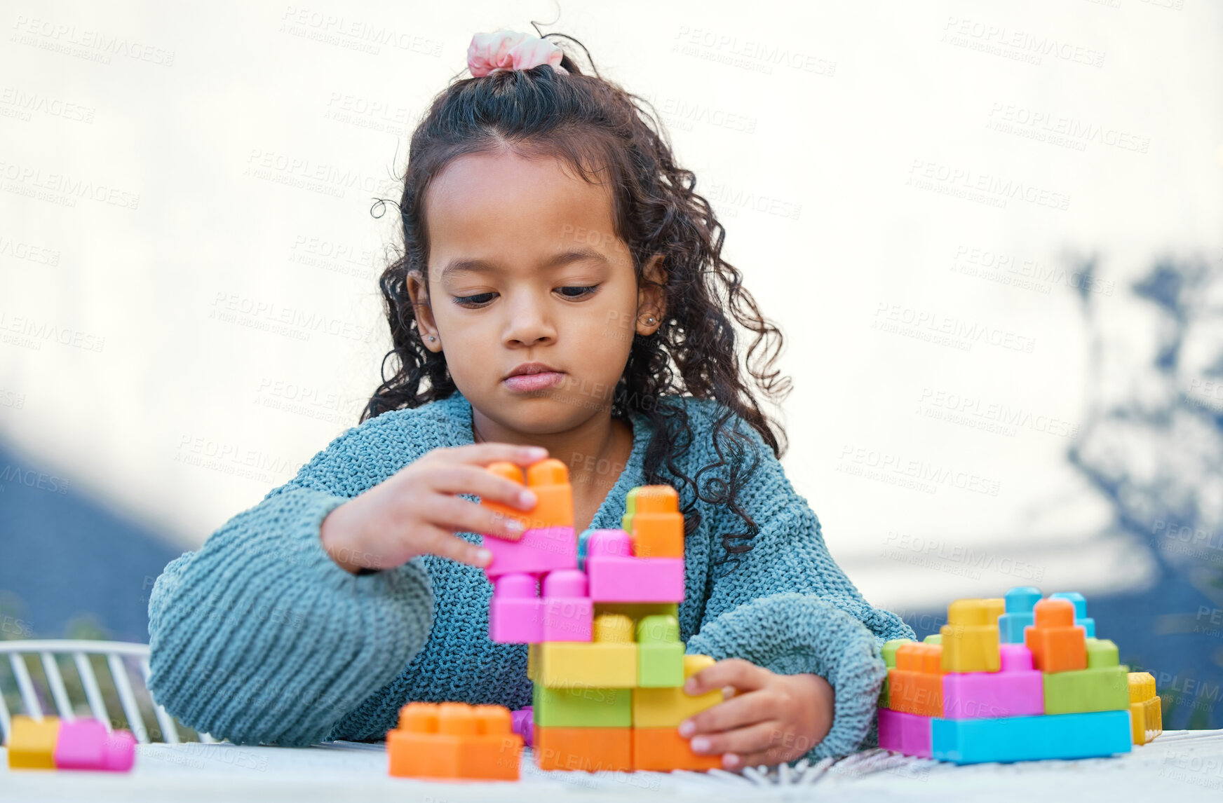 Buy stock photo Shot of a little girl playing with building blocks in her yard