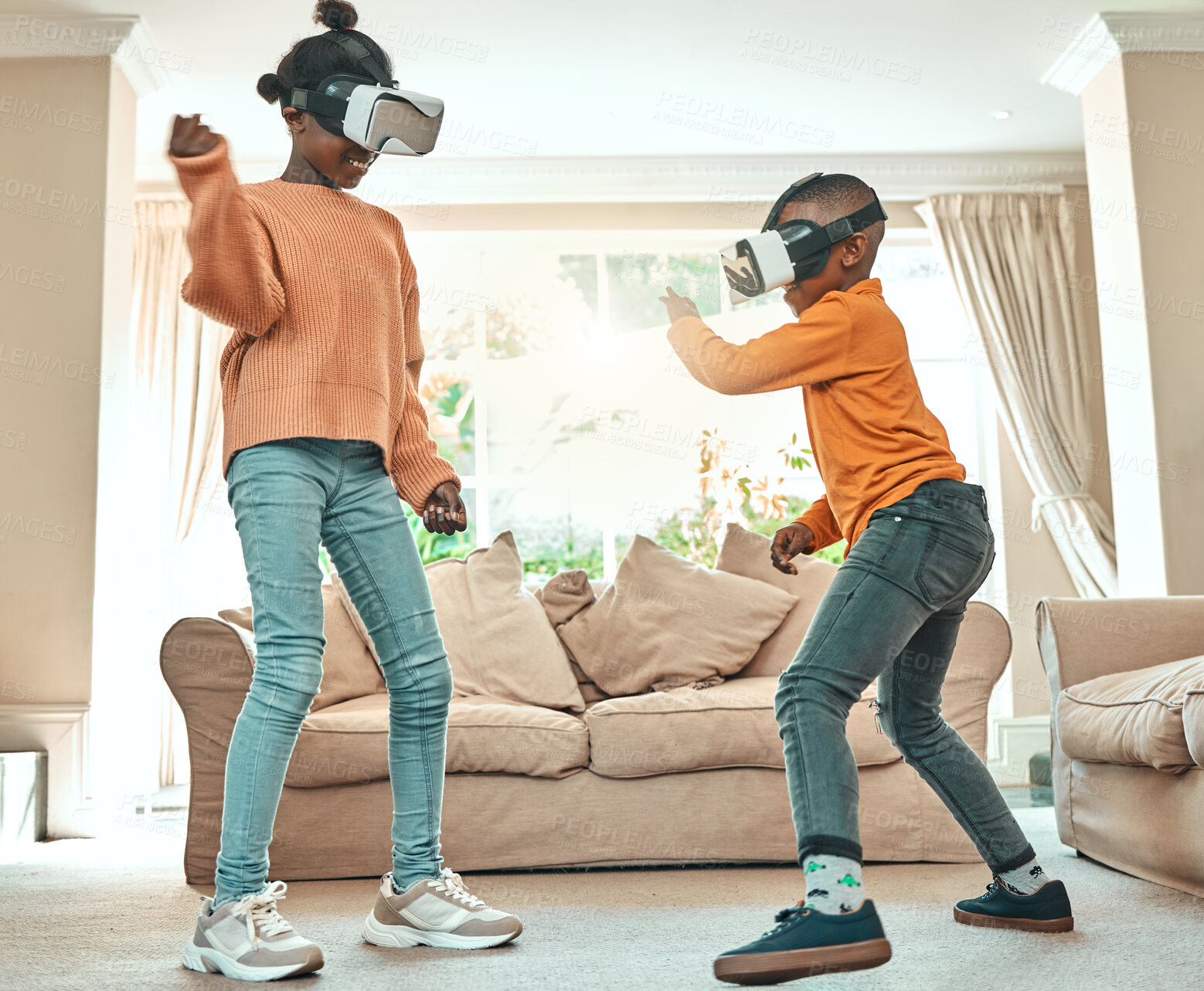 Buy stock photo Shot of a brother and sister playing with each other while wearing VR headsets at home