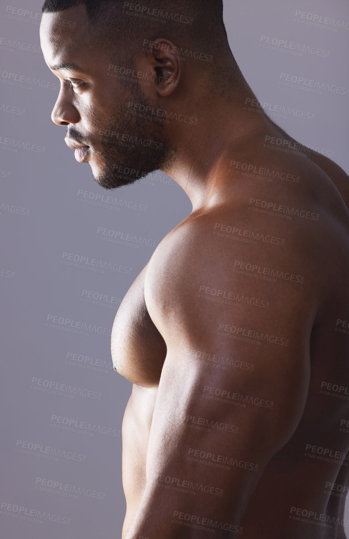 Buy stock photo Studio shot of a handsome and muscular young man posing against a grey background