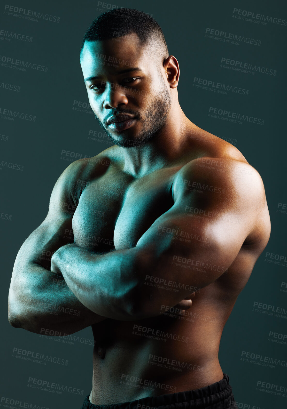 Buy stock photo Studio shot of a handsome and muscular young man posing against a green background