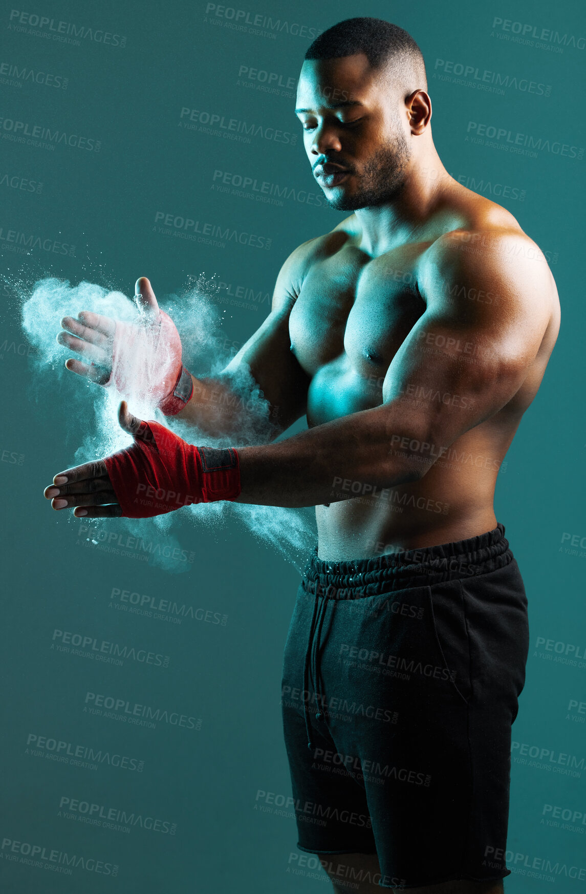 Buy stock photo Shot of a young man dusting his hands with chalk against a studio background