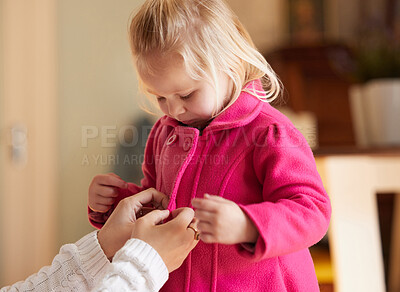 Buy stock photo Shot of a woman buttoning up her daughter's pink coat