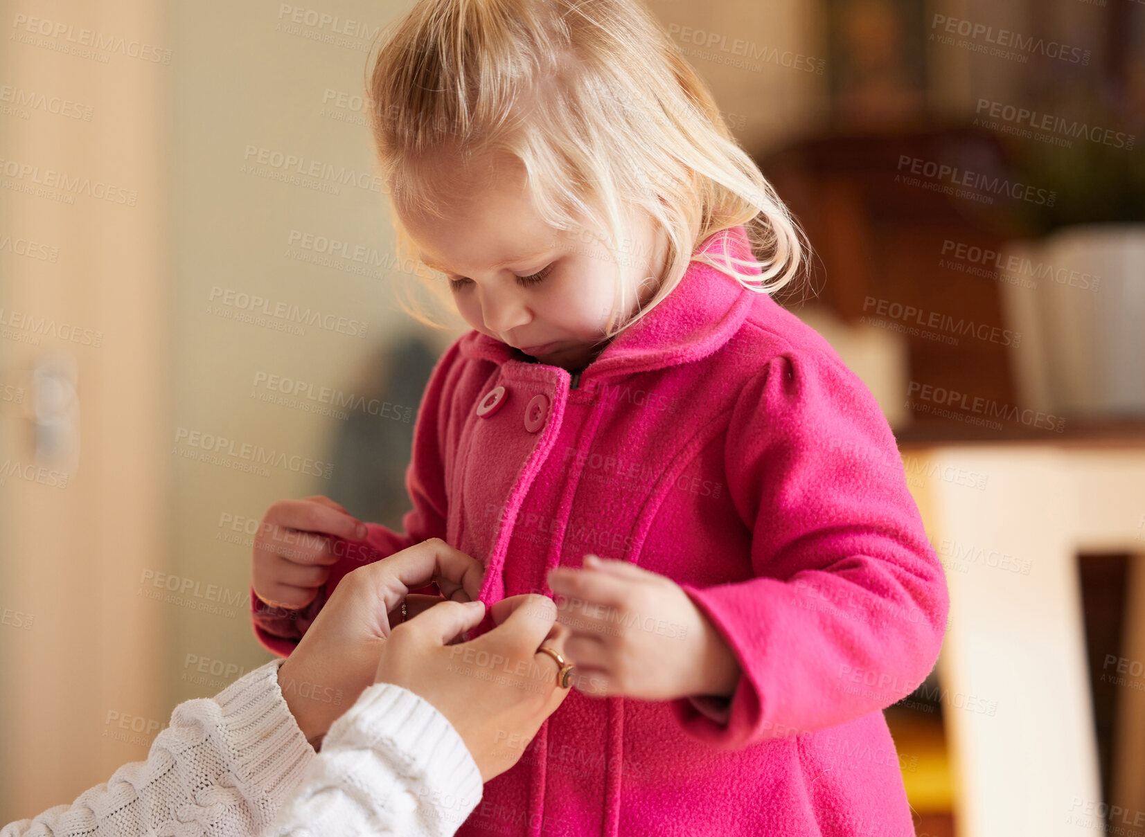 Buy stock photo Shot of a woman buttoning up her daughter's pink coat
