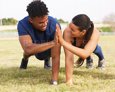 Buy stock photo Shot of two workout partners high fiving during push ups