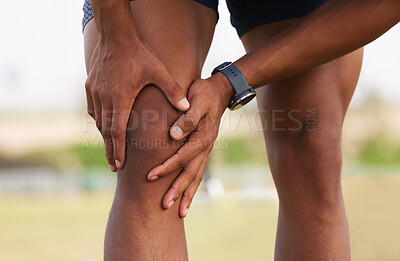 Buy stock photo Shot of a man experiencing a knee cramp during a workout routine