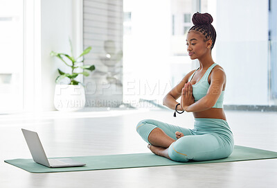 Buy stock photo Full length shot of an attractive young woman sitting with her legs crossed and following an online yoga class