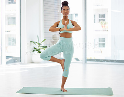 Buy stock photo Full length shot of an attractive young woman practising yoga in the studio and holding a tree pose