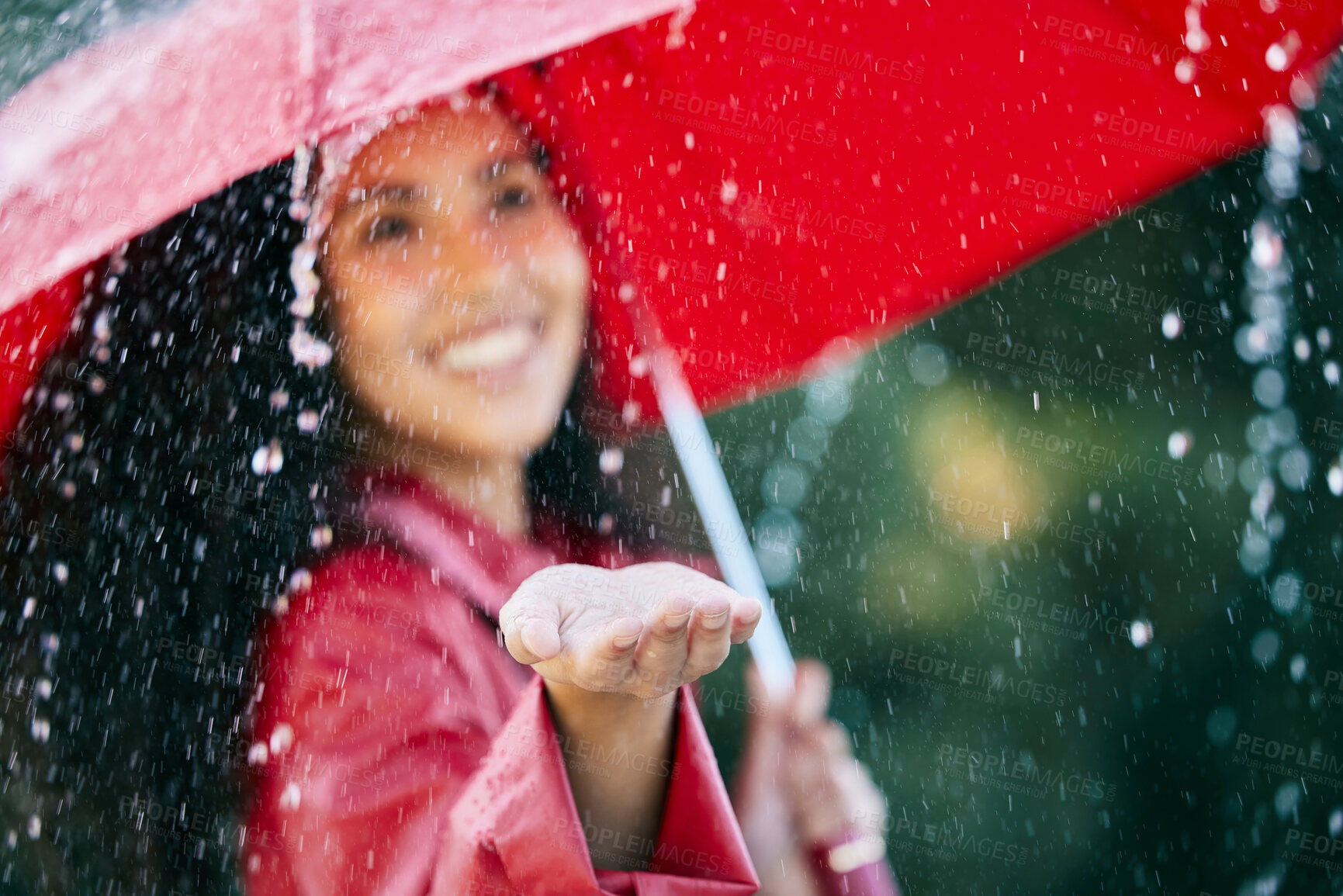 Buy stock photo Closeup shot of a young woman standing in the rain with an umbrella