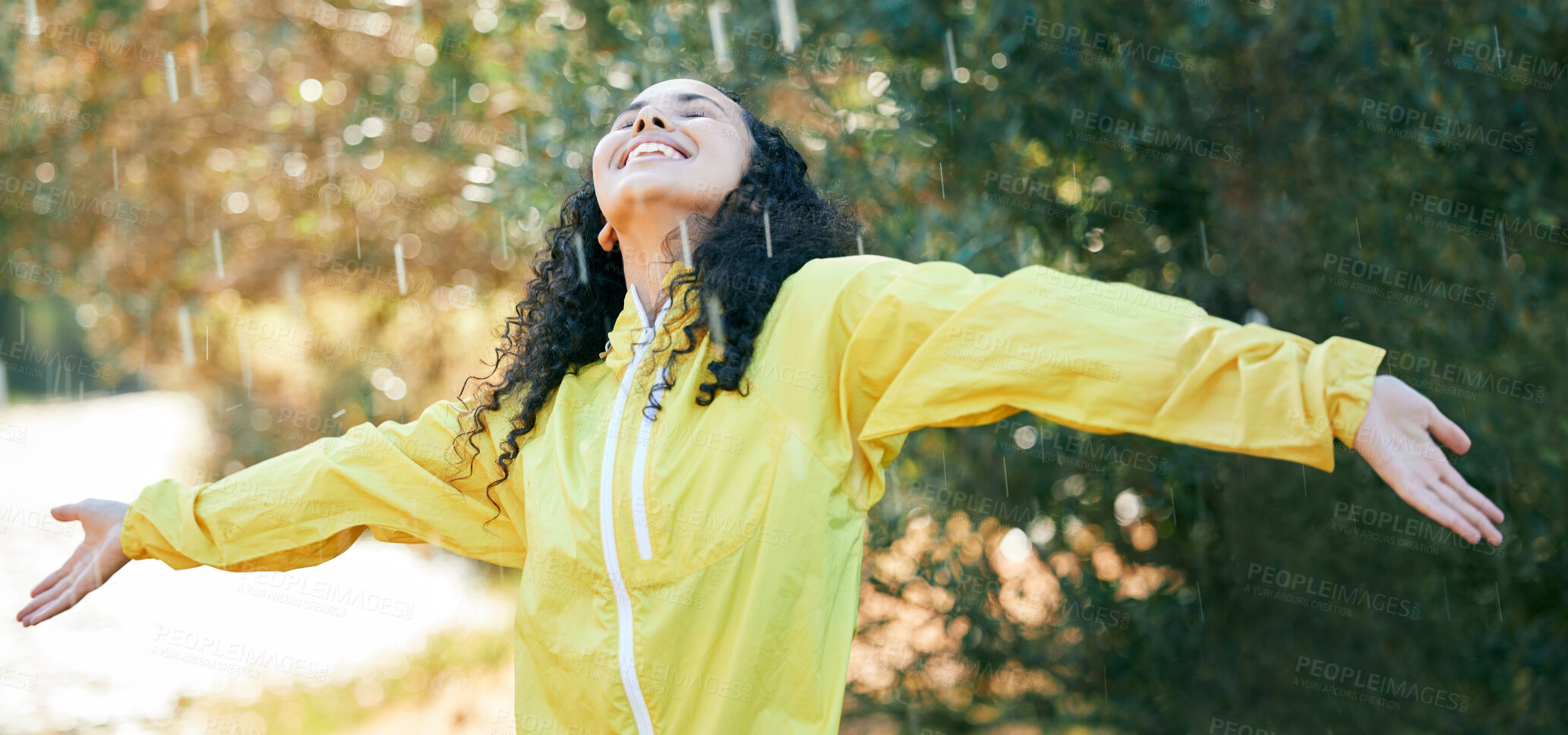 Buy stock photo Shot of a beautiful young woman standing in the rain