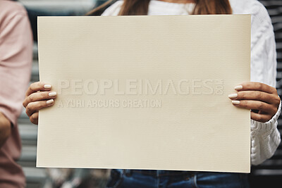Buy stock photo Cropped shot of an unrecognizable woman holding a sign while taking part in a political rally