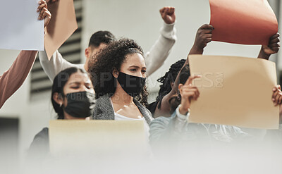 Buy stock photo Low angle shot of a group of people holding signs while taking part in a political rally