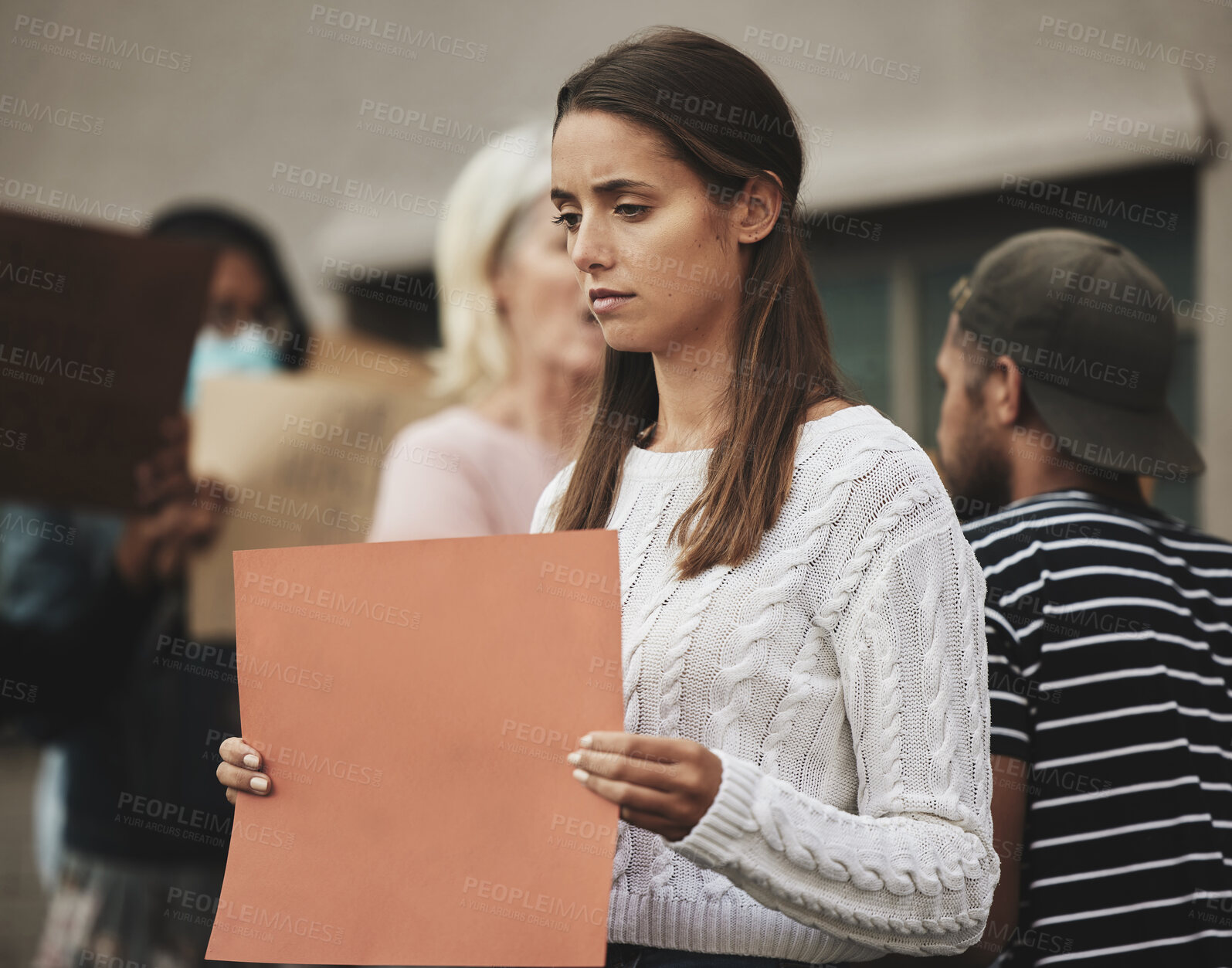 Buy stock photo Cropped shot of an attractive young woman holding a sign while protesting for her rights