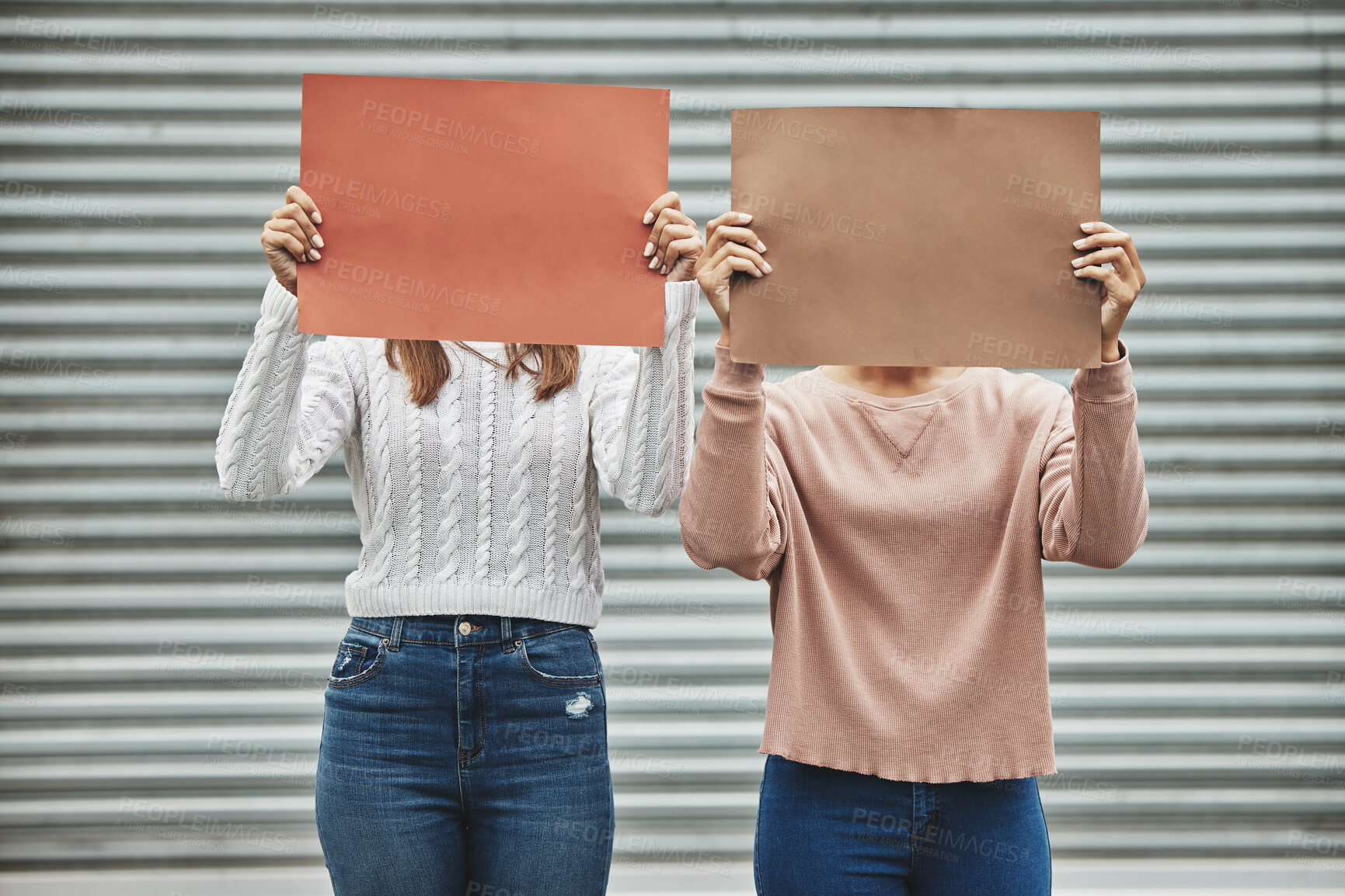 Buy stock photo Cropped shot of two unrecognizable women holding signs while taking part in a political rally