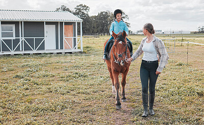 Buy stock photo Shot of a female instructor taking a little girl horse riding