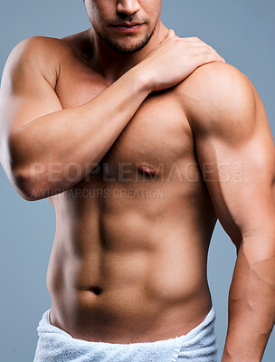 Buy stock photo Cropped shot of a muscular man experiencing pain in his shoulder while posing against a grey background