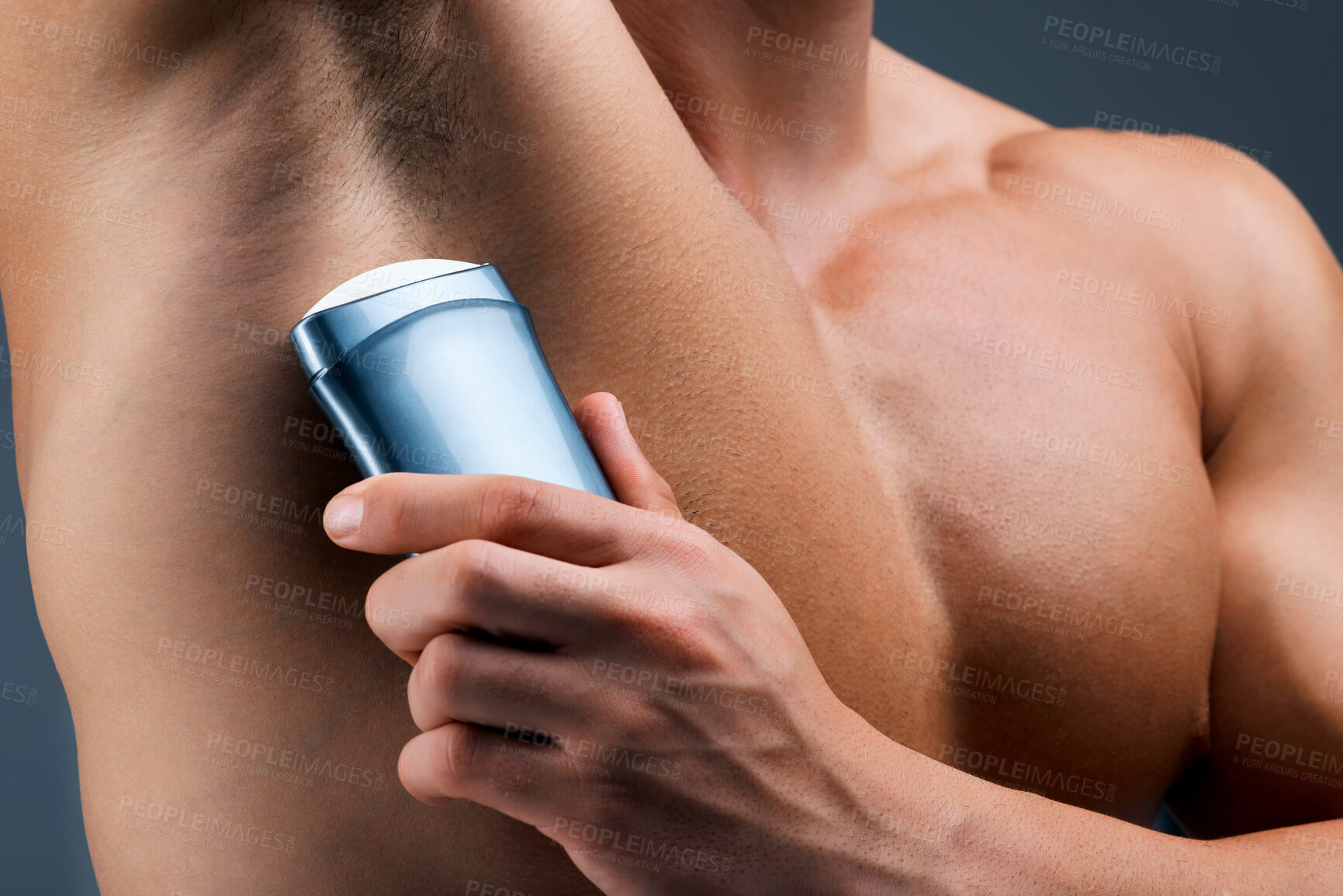 Buy stock photo Studio shot of an unrecognizable man applying deodorant against a grey background