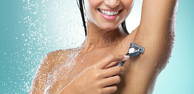 Buy stock photo Shot of a young woman shaving against a blue background