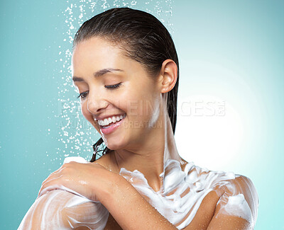 Buy stock photo Shot of a young woman washing her hair in the shower against a blue background