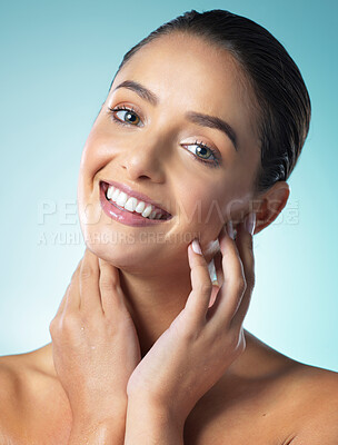 Buy stock photo Shot of a young female touching a her soft skin against a blue background