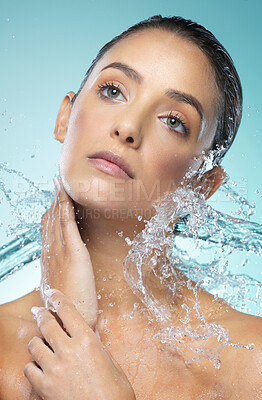 Buy stock photo Shot of a young woman taking a shower against a blue background