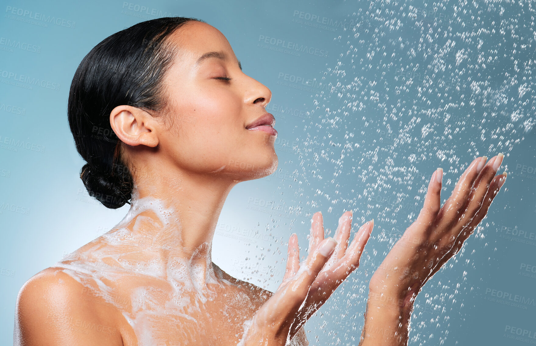 Buy stock photo Shot of an attractive young woman showering against a blue background