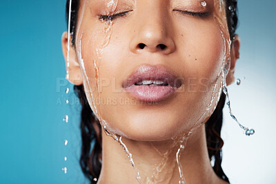 Buy stock photo Cropped shot of an attractive young woman posing against a blue background while taking a shower