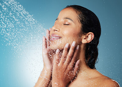Buy stock photo Shot of an attractive young woman showering against a blue background