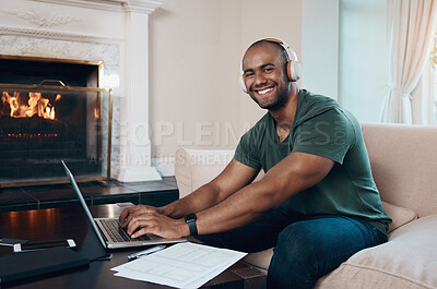 Buy stock photo Shot of a young businessman working on his laptop while listening to music