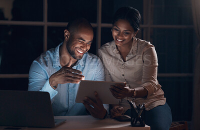 Buy stock photo Shot of a young couple using a digital tablet together at night