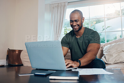 Buy stock photo Shot of a young man using his laptop while working from home