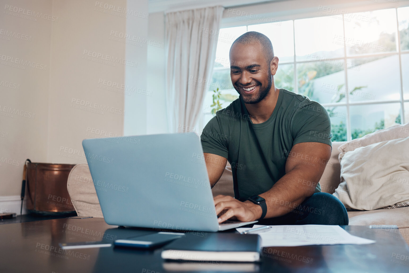 Buy stock photo Shot of a young man using his laptop while working from home