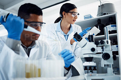Buy stock photo Shot of two young scientists using a digital tablet while conducting medical research in a laboratory