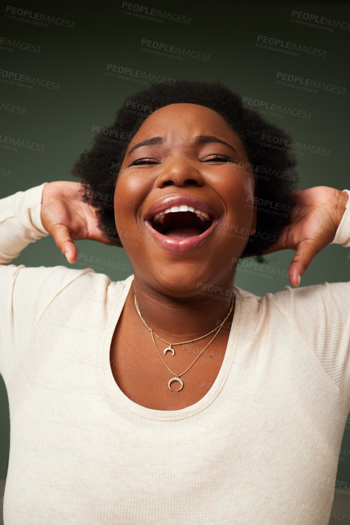 Buy stock photo Shot of an attractive young woman laughing while posing against a green background in the studio